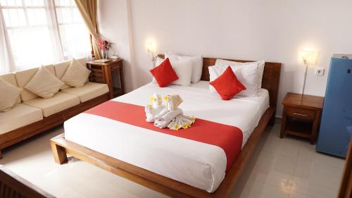 a hotel room with a bed and a couch at Grand Raka Homestay in Lovina