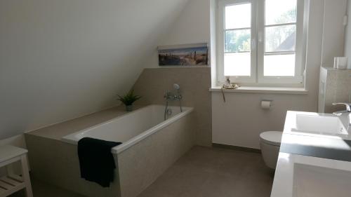 a bathroom with a tub and a toilet and a sink at Knut in Mellnitz