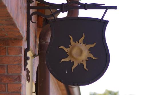 a black shield hanging on the side of a building at Ubytování a apartmány Sluníčko in Lomnice nad Lužnicí