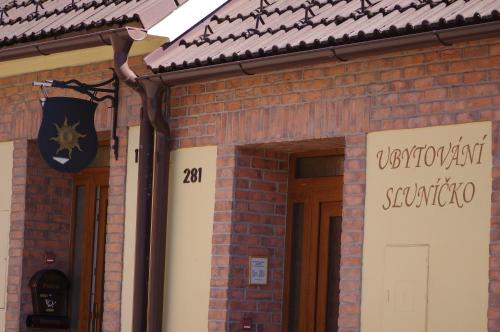 a brick building with a sign on the front of it at Ubytování a apartmány Sluníčko in Lomnice nad Lužnicí
