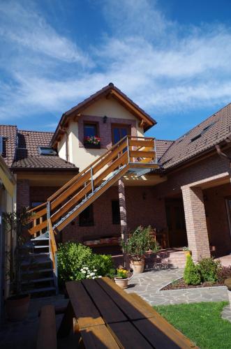 a house with a wooden staircase in front of it at Ubytování a apartmány Sluníčko in Lomnice nad Lužnicí
