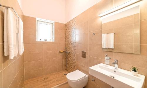a bathroom with a toilet and a sink at Vista Mare Maxima Beheizter Pool in Dhrámia