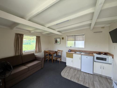 a living room with a couch and a table at Picton's Waikawa Bay Holiday Park in Picton