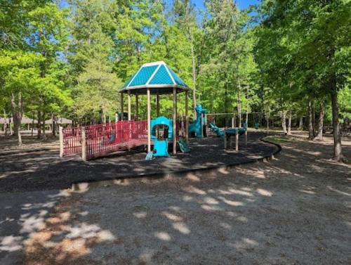 a playground in a park with a blue playgroundvisor at Aviation Haven 5 Mins to RIC, Ready for Takeoff! in Capitol View