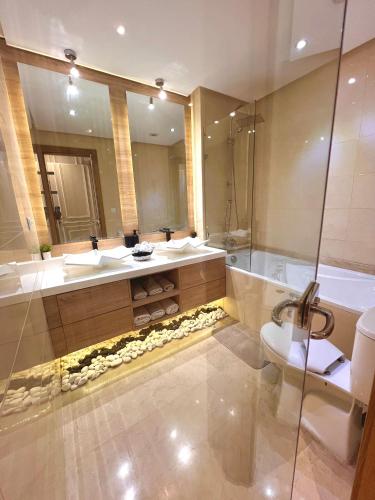 a bathroom with two sinks and a tub and a toilet at Appartement Luxueux Casa Nearshore in Casablanca