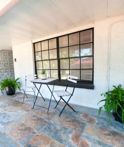a patio with a table and chairs in front of a window at Cozy apartment near Busch Gardens Adventure Island and USF in Tampa