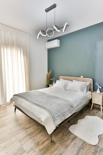 a bedroom with a large bed and a blue wall at LĀr - the Hidden Gem in Anatolí