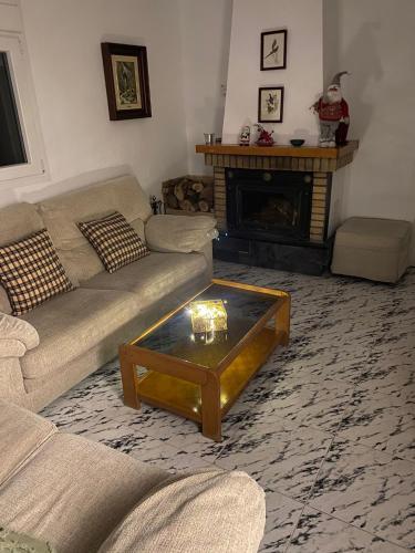 a living room with a couch and a fireplace at Casa rural Balcón de Monachil in Monachil