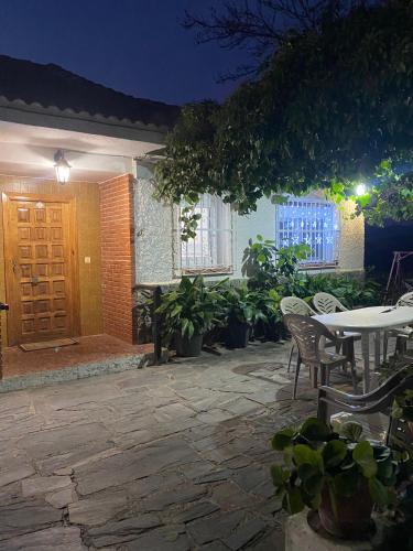 a patio with a table and chairs and a door at Casa rural Balcón de Monachil in Monachil
