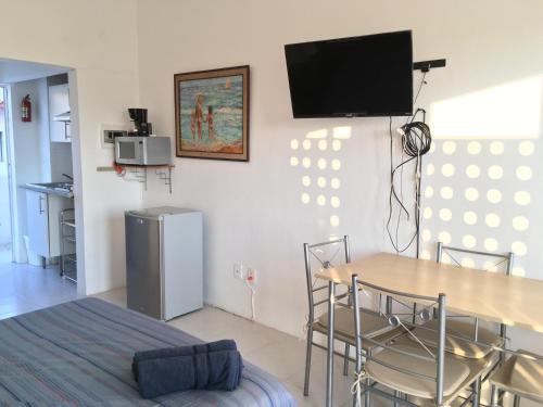 a dining room with a table and a television on a wall at Departamento con vista al mar in Acapulco