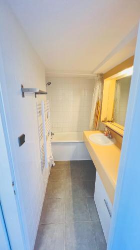 une salle de bain avec un lavabo et une baignoire dans l'établissement Location appartement Chamrousse 1650 - Superbe vue, à Chamrousse