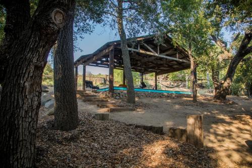 a wooden pavilion in a park with trees at Historic Farmhouse on 5 Peaceful Acres with Ancient Oaks & Creek above Temecula in Temecula