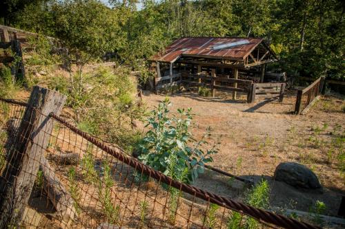 a fence in front of a barn with a building at Historic Farmhouse on 5 Peaceful Acres with Ancient Oaks & Creek above Temecula in Temecula