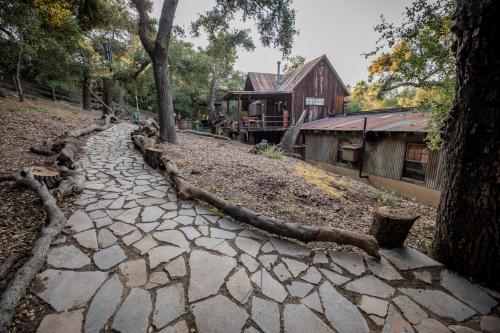a stone path next to a house and a building at Historic Farmhouse on 5 Peaceful Acres with Ancient Oaks & Creek above Temecula in Temecula