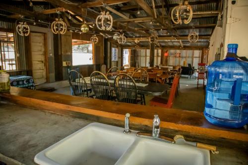 a kitchen with a sink and a table with chairs at Historic Farmhouse on 5 Peaceful Acres with Ancient Oaks & Creek above Temecula in Temecula