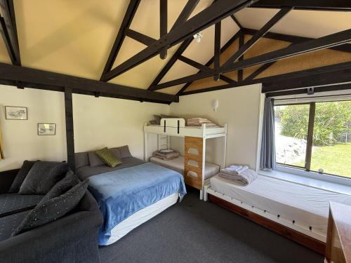 a room with a bed and a couch and a window at Picton's Waikawa Bay Holiday Park in Picton