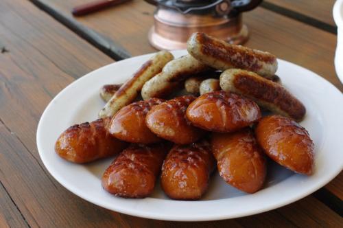 a plate of sausages and saucers on a table at Ubytování a apartmány Sluníčko in Lomnice nad Lužnicí