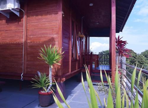 a porch of a house with potted plants on it at Grand Raka Homestay in Lovina