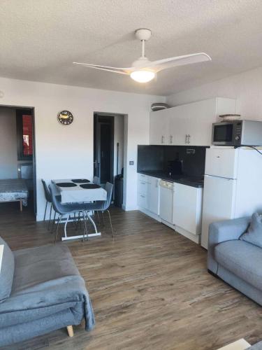 un salon avec un canapé et une table et une cuisine dans l'établissement Résidence Palmyra - T2 5 PERS - LE BARCARES- piscine incluse MAE-3964, au Barcarès