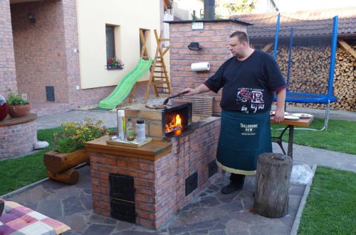 a man standing in front of a brick oven at Ubytování a apartmány Sluníčko in Lomnice nad Lužnicí