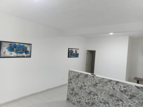 a white room with two pictures on the wall at Departamento Suite in Hércules
