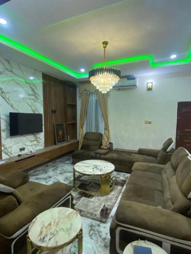 a living room with couches and a tv and green lights at Your Elegant Home in Lagos