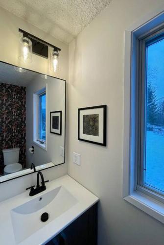 a white bathroom with a sink and a mirror at Nell's Mountain Lodge - Arcade Hottub Fire Pit 5 Acres in Golden