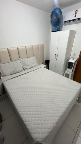 a bed in a room with a white mattress at Apto Ipojuca Caruaru in Caruaru