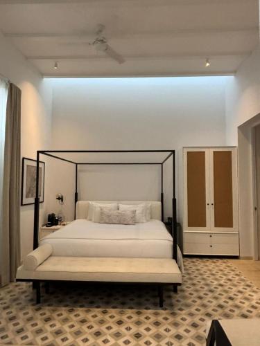 a bedroom with a large bed with a black frame at Casa Continental Hotel Boutique & Suites - Adults Only in Mérida