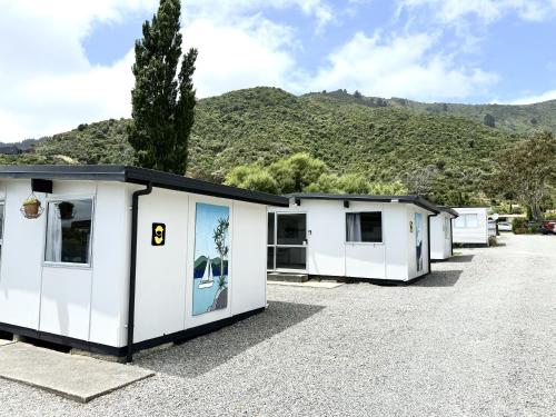 a row of white mobile homes in a parking lot at Picton's Waikawa Bay Holiday Park in Picton
