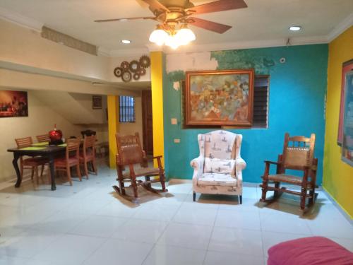 una habitación con sillas y una mesa con una pintura en la pared en Hotel Gues, en La Guaca