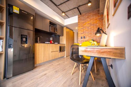 a kitchen with a wooden table and a refrigerator at Skyline Suites - Elegant Living with Coworking & Scenic Views in Bogotá
