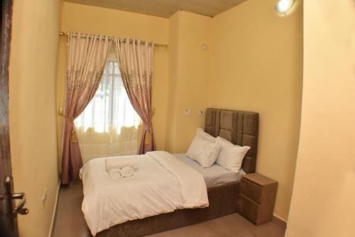 a bedroom with a bed with two towels on it at AC-Apartments in Asaba
