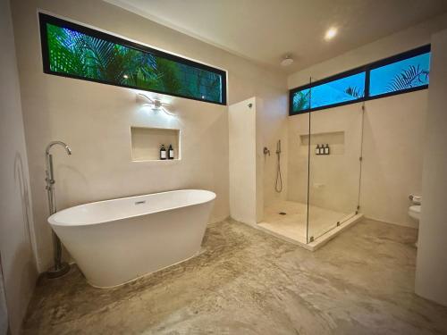 a bathroom with a large tub and a shower at Stunning Villa in the heart of La Veleta in Tulum