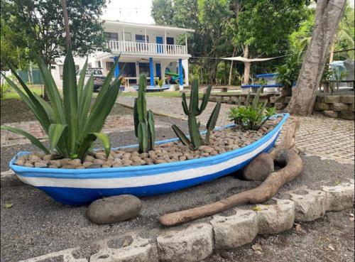 a blue boat with some plants in a yard at Tivives kikala Lodge in Esparza