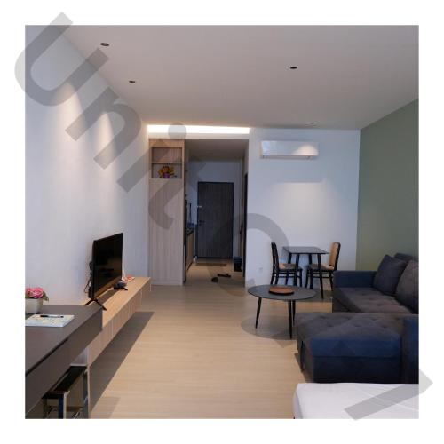 a living room with a couch and a table at 7th Horizon - Roxy Sematan Beach Apartment in Sematan