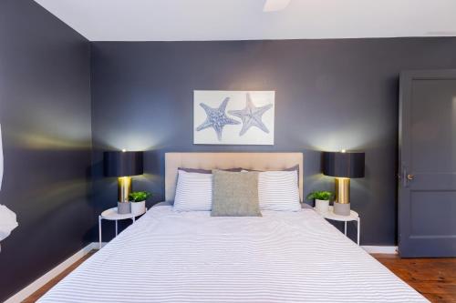 a bedroom with a large white bed with two lamps at Cozy Beach Cottage Near The Bay in Villas