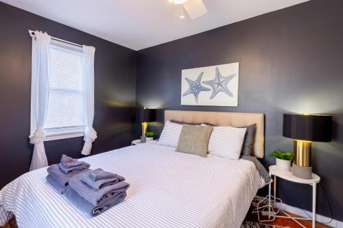 a bedroom with a large white bed with blue walls at Cozy Beach Cottage Near The Bay in Villas