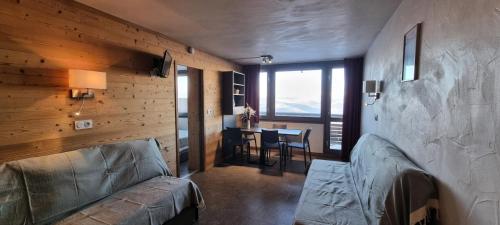 un salon avec un canapé et une salle à manger avec une table dans l'établissement Résidence Zenith - 2 Pièces pour 5 Personnes 884, à Aime La Plagne