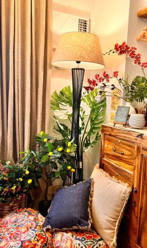 a lamp in the corner of a room with plants at SMDC Green 2 Staycation, The Traditional & Modern Fusion Condo in Pasong Bayog