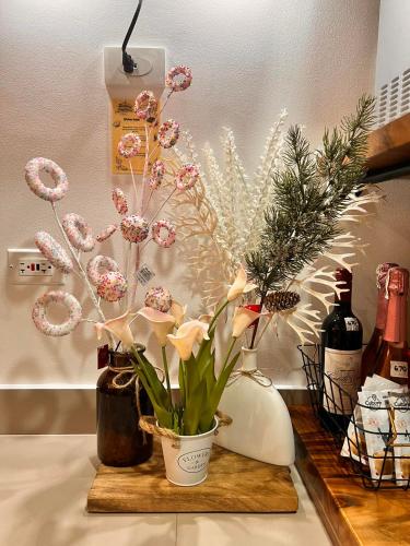 a vase of flowers on a counter with christmas decorations at SMDC Green 2 Staycation, The Traditional & Modern Fusion Condo in Pasong Bayog