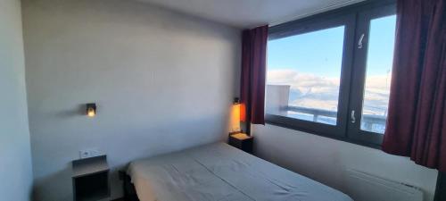une chambre avec un lit et une grande fenêtre dans l'établissement Résidence Zenith - 2 Pièces pour 5 Personnes 884, à Aime La Plagne