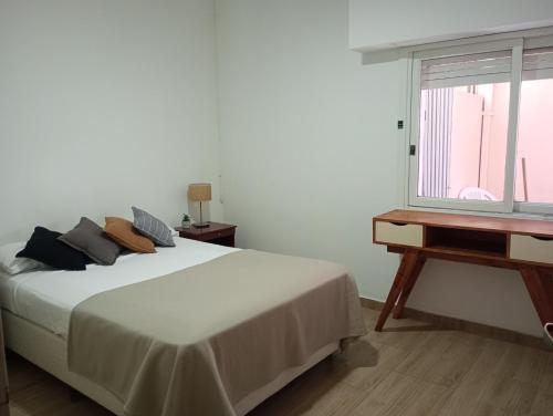 a white bedroom with a bed and a window at Mercedes Aparts in Mercedes