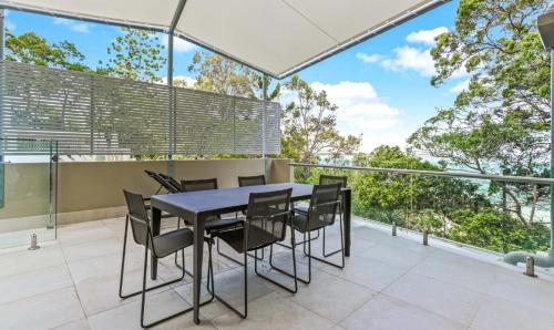 a dining table and chairs on the balcony of a house at Little Cove Court - Apt 5 Newly Renovated in Noosa Heads