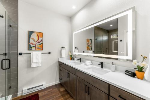 ein Badezimmer mit zwei Waschbecken und einem großen Spiegel in der Unterkunft The Downtown Duplex - Pet Friendly - NEW BUILD in Colorado Springs
