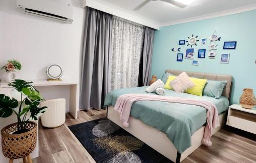 ゴールドコーストにあるBeachside Apartment in the Heart of Surfers Paradise - free parkingの青い壁のベッドルーム1室、カラフルな枕付きのベッド1台が備わります。