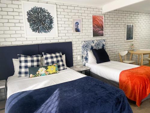 a bedroom with two beds and a table at Mulwala Resort in Mulwala