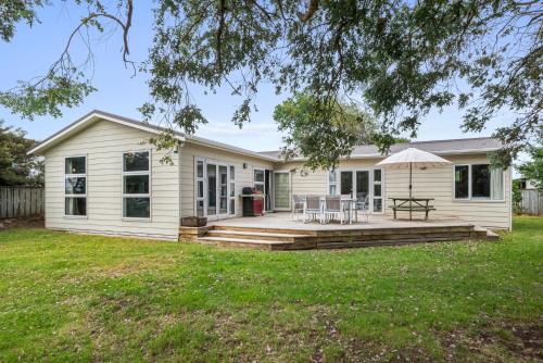 a home with a large porch and a deck at Coastal Family Escape - Waitarere Beach Retreat in Levin