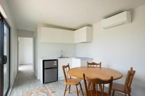 a kitchen with a table and chairs in a room at Coastal Family Escape - Waitarere Beach Retreat in Levin