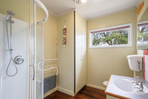 a bathroom with a shower and a sink at Coastal Family Escape - Waitarere Beach Retreat in Levin